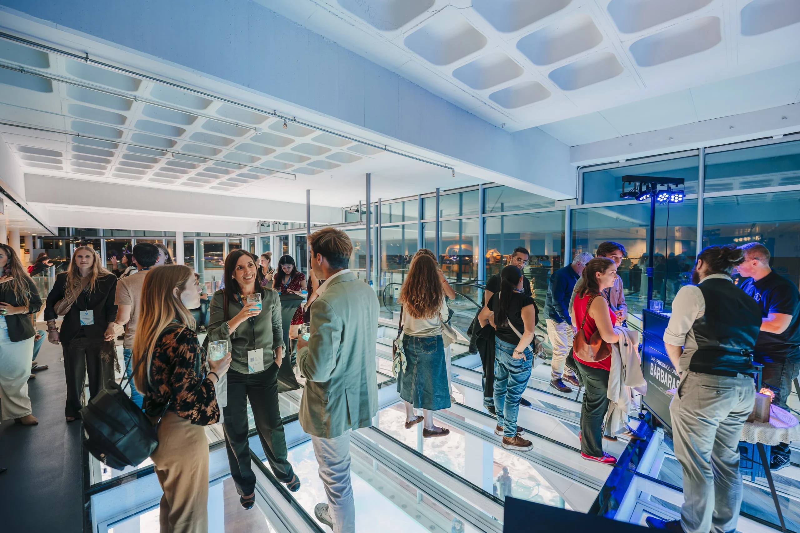 Un grupo participa en una dinámica de empresa dentro de Viewpoint luminoso de L’Aquàrium de Barcelona.